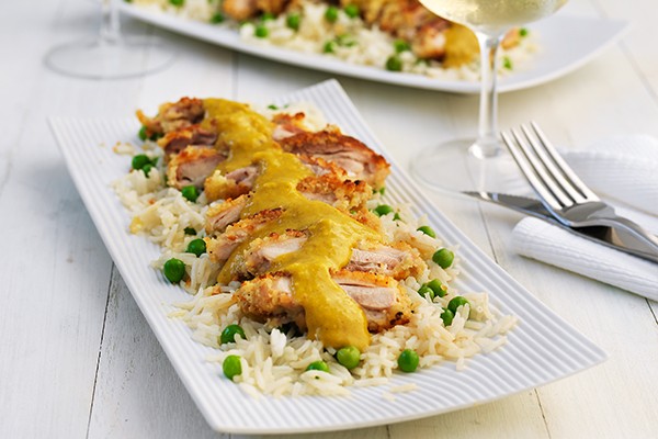 Breaded chicken fillets with katsu sauce, on a bed of rice and peas