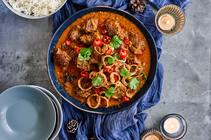 Pan of beef shin rendang curry topped with coriander and chilli