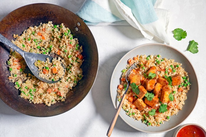 A cauliflower rice dish with a red sauce on the side