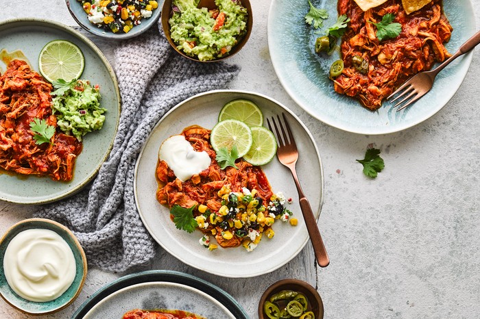 A plate of Mexican chicken with lime slices and coriander