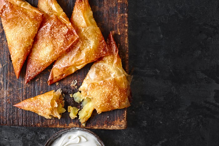 Four apple samosas with yogurt